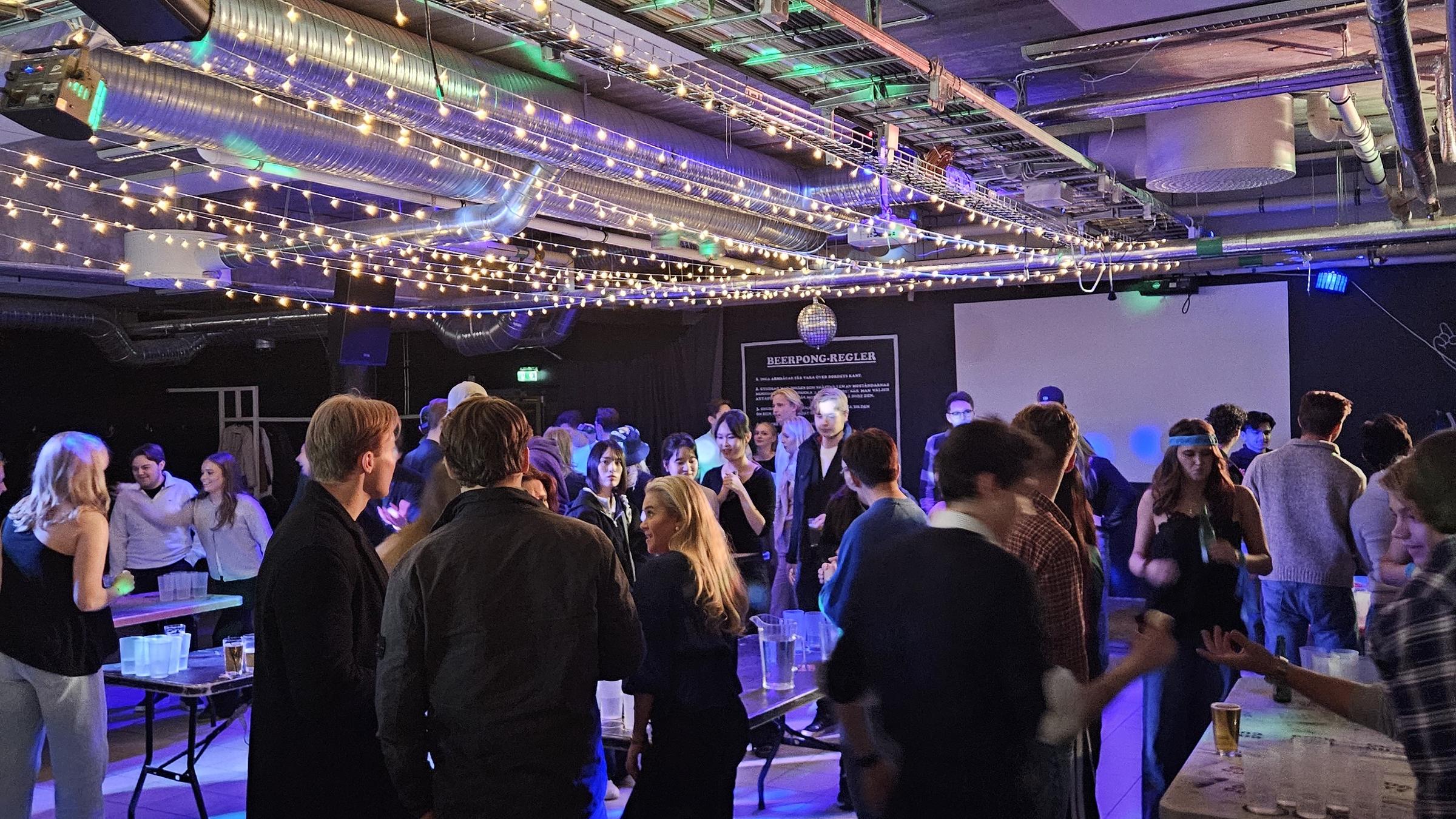 En kväll på C.A.P.S, fullt golv under ljusslingorna, sett från baren